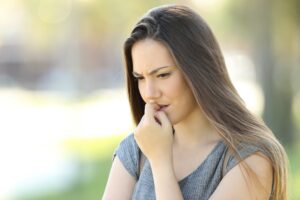 anxious woman biting nails